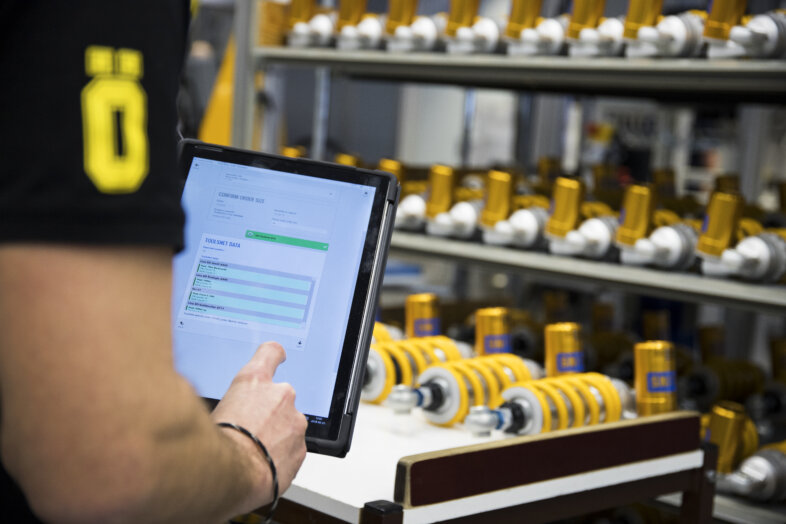 Employee at Öhlins Racing managing production workflow on tablet, image by Novacura