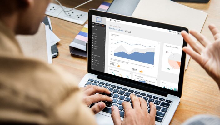 Professionals reviewing business charts on laptop, demonstrating what is low code, image by Novacura